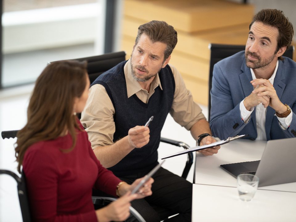 A client consultation in progress around a meeting table.